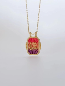 Detailed shot of golden tarot pendant with Love is the Answer text and crystal edges
