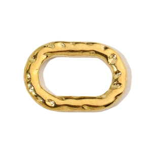Close-up of golden oval hammered texture charm with metallic finish for jewelry making