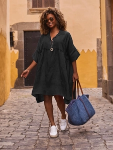 Detail of loose black polo neck shirt dress with buttons and breathable cotton fabric