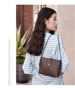 Detail of vintage geometric pattern shoulder bag on model against brick wall