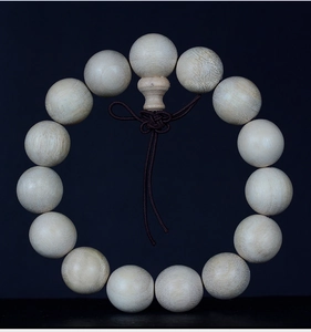 Detail of natural camphor wood beads with fine grain and elegant Chinese knot on black