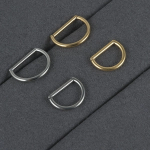 Macro detail of titanium D-ring buckles in gold and silver finish for piercings