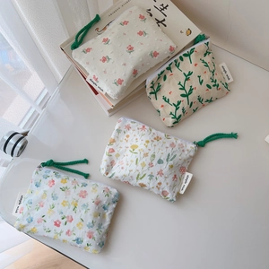 Close-up of small floral cotton coin purses with cord zippers and simple wish tags