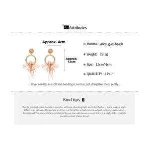 Detailed view of bohemian lace flower earrings with pink tassels and silver needles