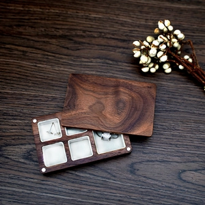 Macro shot of walnut wood jewelry box with white velvet six-slot interior for rings