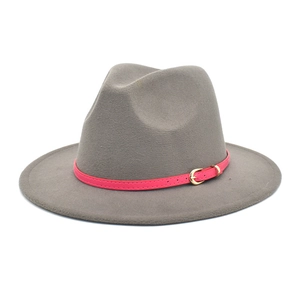 Detail of grey fedora wool hat with bright pink leather belt and golden horseshoe buckle