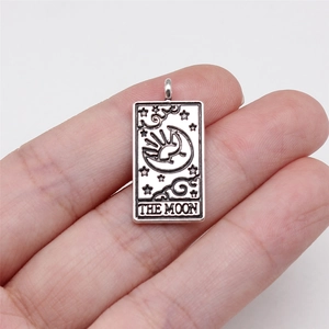 Silver vintage tarot card pendant featuring The Moon design held in hand for size display
