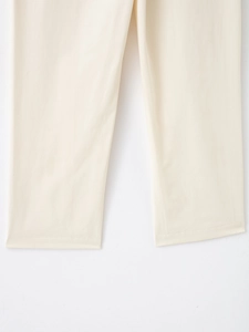 Détail d'un pantalon décontracté beige montrant la coupe droite et la texture du tissu