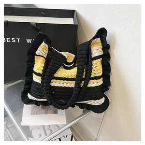 Detailed view of handmade knitted tote bag with black, yellow, and white ruffled stripes