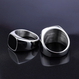 Macro shot of men's square black signet ring with silver polished stainless steel texture
