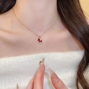 Close-up of gold plated horse necklace with red enamel and sparkling cubic zirconia