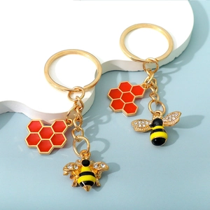Detail of bee and honeycomb keychains with enamel colors and sparkling rhinestones