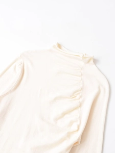 Detail view of the elegant pleated shoulders and mock neck on this wool knit top