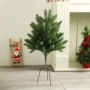 Realistic mini spruce Christmas tree with dark green needles and a black metal tripod stand