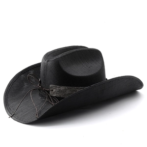 Détail d'un chapeau de cowboy en paille noire tressée avec cordon brun et bande de perles bois