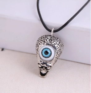 Macro shot of silver gothic skull pendant with detailed brain texture and blue devil eye