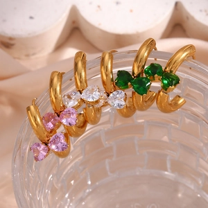 Detailed shot of gold hoop earrings with pink, white, and green crystal heart charms