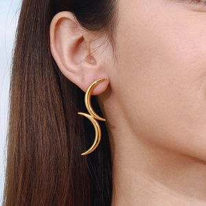 Detailed view of elegant gold stainless steel earrings with fluid flame-shaped design