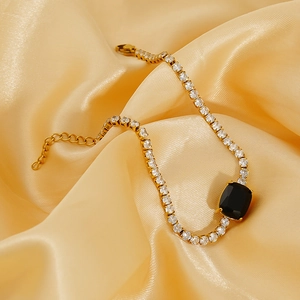 Adjustable gold plated tennis bracelet featuring black rectangular stone and clear zircons