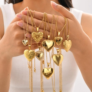 Detailed view of various gold heart locket necklaces with rhinestones worn by a model