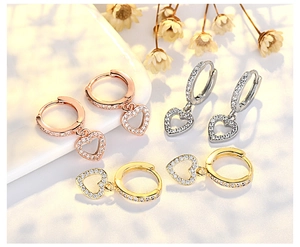Detailed view of three pairs of S925 sterling silver heart hoop earrings with CZ
