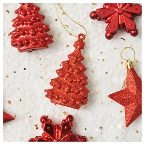 Sparkly red Christmas tree and star ornaments on white snow background with gold sequins