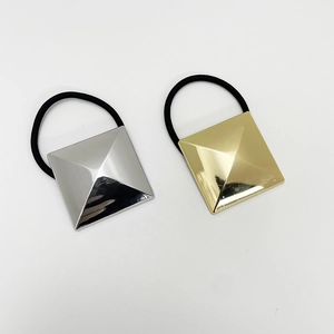 Detail of silver and gold pyramid metal charms on high-elastic black hair ties