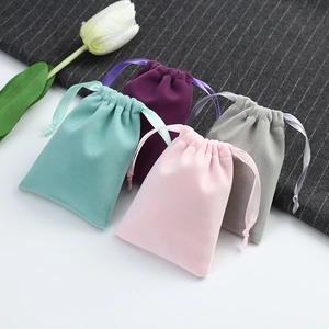 Detail of velvet drawstring jewelry pouches in mint, purple, pink and grey colors