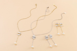 Detailed set of gold and silver necklaces and earrings with shell discs and pearl tassels