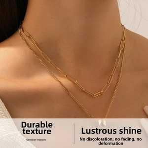 Detail of layered gold double-chain necklace with heart pendant on neck