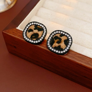 Close-up of square leopard print earrings with sparkling rhinestone border on display