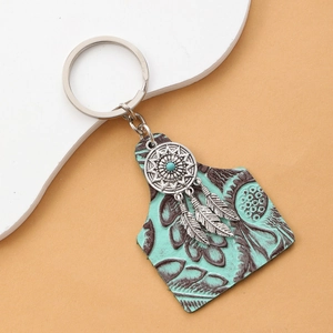 Bohemian keychain with teal embossed leather tag and silver dreamcatcher feather charms