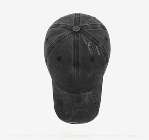 Detail shot of distressed black denim cap with red 3D embroidery on a grey background