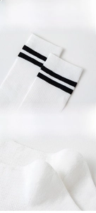 Detailed view of white calf socks with black stripes featuring elastic anti-slip cuffs