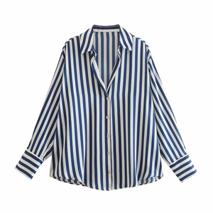 Détail d'une chemise à manches longues rayée bleu et blanc avec poignets horizontaux