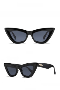 Macro view of cat-eye sunglasses featuring black frames and purple lenses with gold hinges