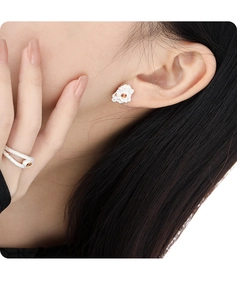 Close-up of S925 silver irregular lava texture earring and ring with orange gems on model