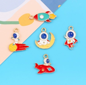 Detail view of five enamel space charms including astronaut and rocket for DIY jewelry