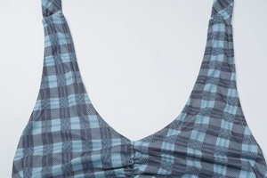 Vue détaillée du tissu à carreaux bleu et gris avec col en V et détails froncés centraux