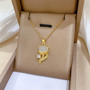 Macro view of gold fox pendant necklace with white opal and glittering zircon details