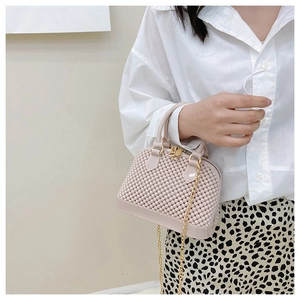 Close-up of beige jelly shell bag with beaded texture and gold chain strap