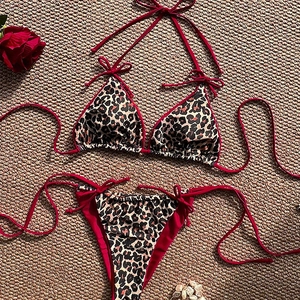 Two-piece leopard print bikini set with red contrast straps and tie-side bottoms