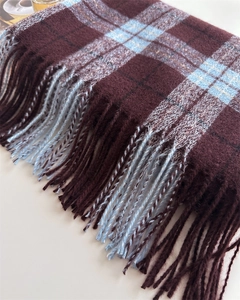 Détail d'une écharpe à carreaux britanniques avec franges bordeaux et texture douce