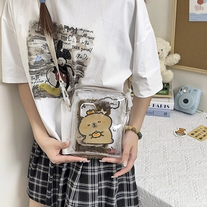Clear crossbody bag with cute brown capybara plush insert on a stylish lifestyle desk