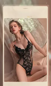 Detailed view of black floral lace bodysuit with mesh panel and bow detail in bedroom