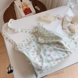 Detail shot of a floral cotton tote bag with colorful botanical prints on a white table