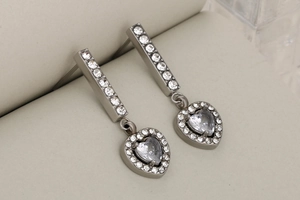 Dettaglio di orecchini a cuore in argento con zirconi brillanti e design a doppio strato