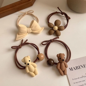 Detail of high-elastic hair ties set with resin bear, flower, and bow charms