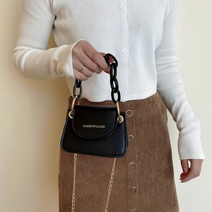Mini black jelly flap bag with chunky chain handle and gold shoulder strap for women