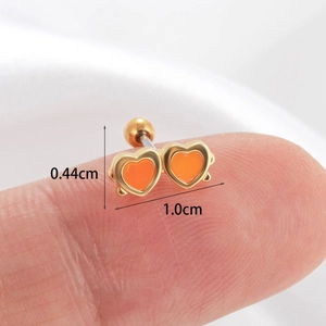 Detailed size view of double heart studs in orange enamel and gold finish on fingertip